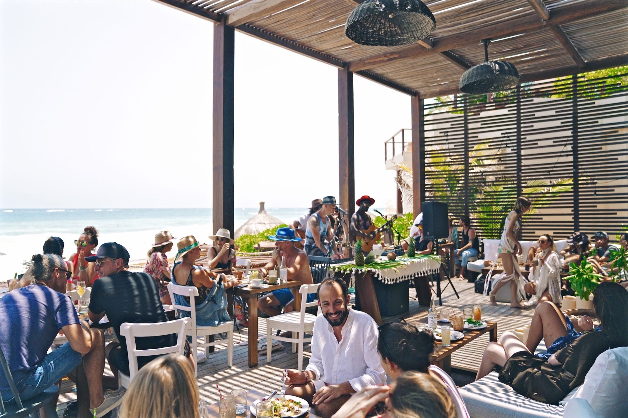 The deck at Sanará, full, with music, the sea beyond